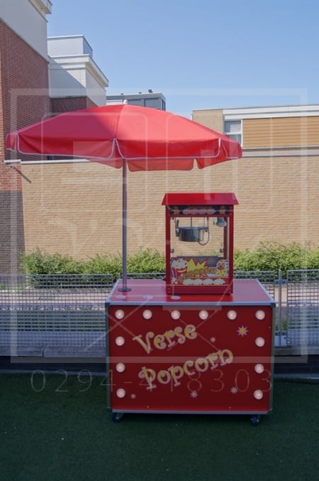 Popcornmachine op leuke kar met verlichting en parasol.